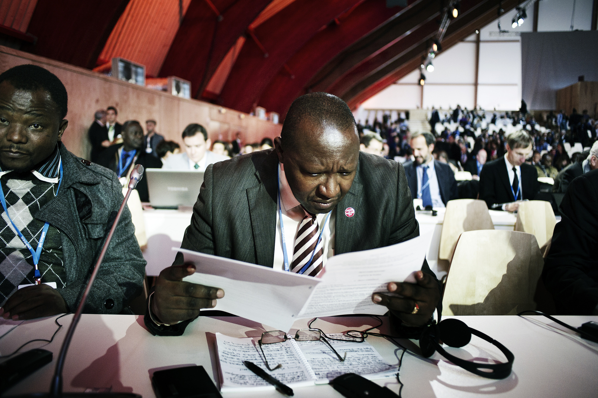 Negotiators look over the new text of the COP21 climate agreement, December 9, 2015. Photo: Benjamin Géminel / COP21
