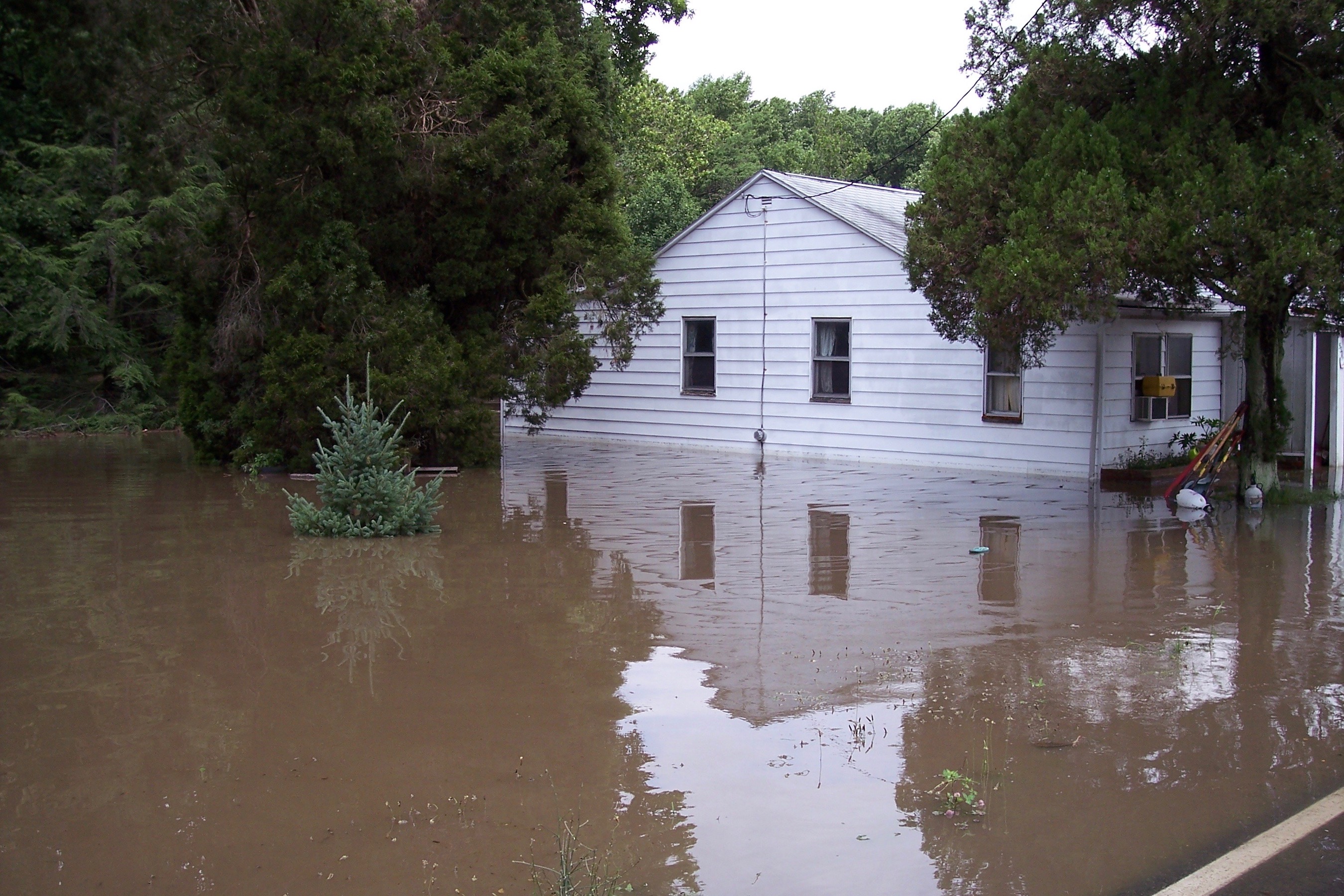 Only the second floor of a house is visible in flood waters