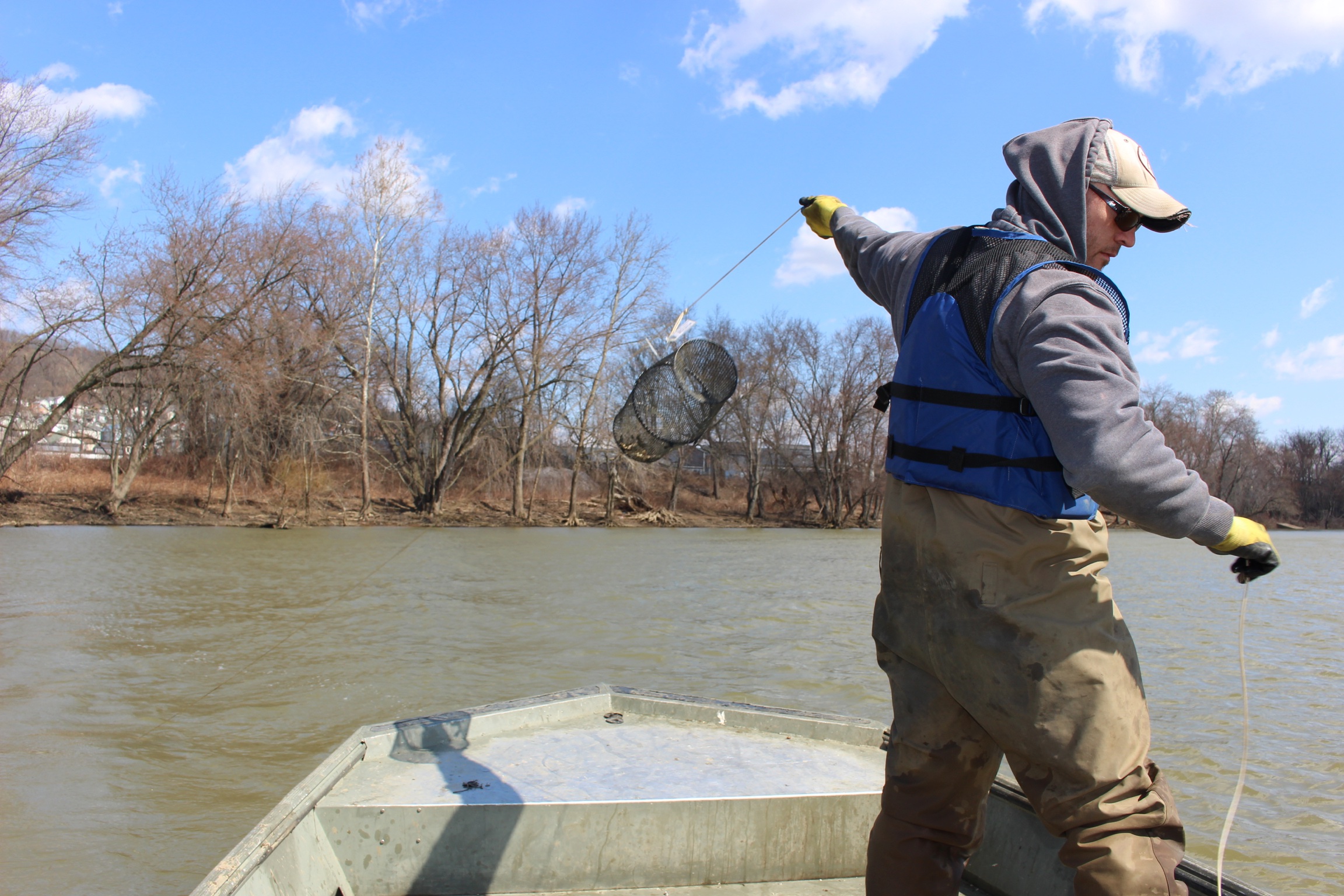 Nevin Welte standing on a small boat in the Allegheny River.