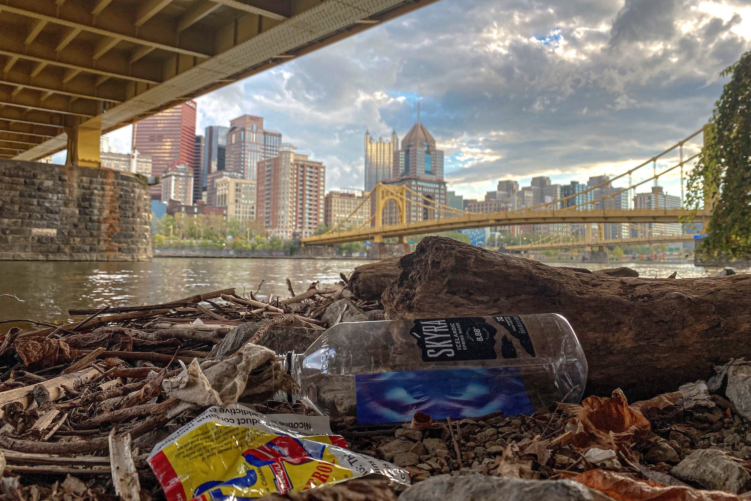 A view of Downtown Pittsburgh from under a bridge with litter.