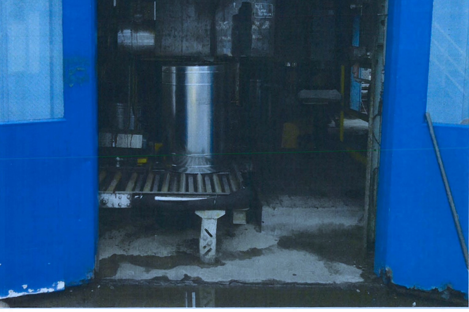 A drum with liquid leaking on the floor.