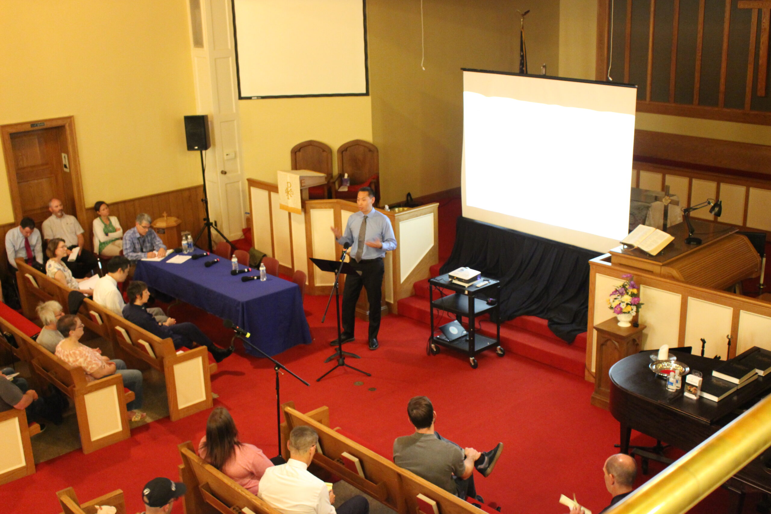 Dr. Arthur Chang in a church, speaking to a crowd