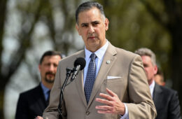 man standing in suit at podium