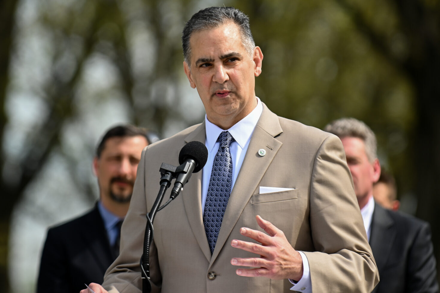 man standing in suit at podium