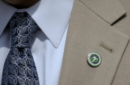 Grey suit with bade pinned on lapel
