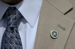 Grey suit with bade pinned on lapel