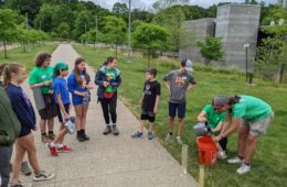 Kids stand in a semi-circle in front of Frick Environmental Center