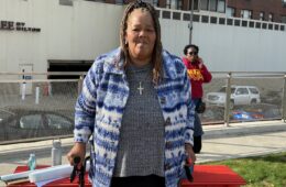 A Black woman stands in front of a table in Downtown Pittsburgh