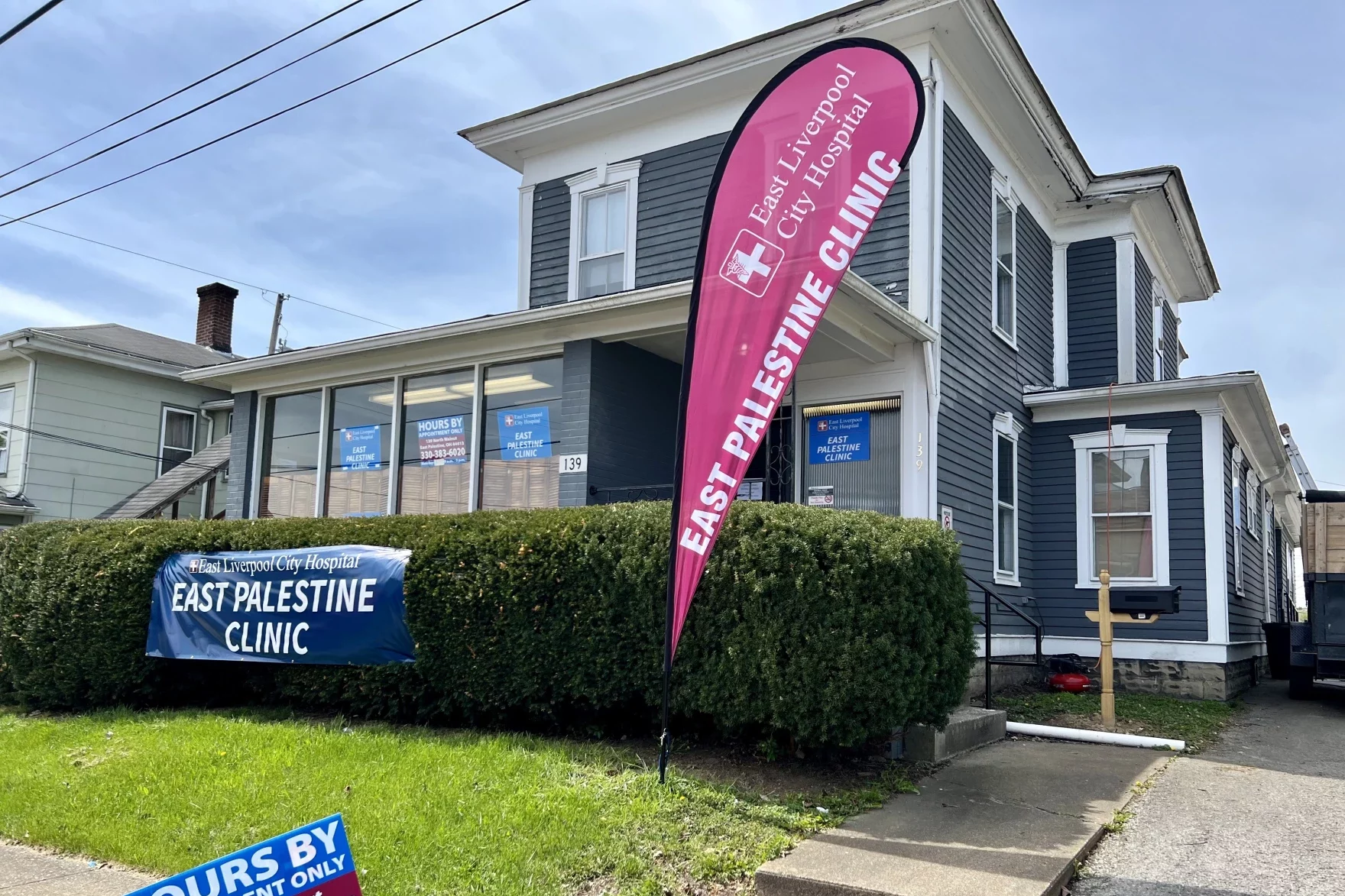A large 2-story home turned into an office, with a banner outside reading "East Palestine Clnic"