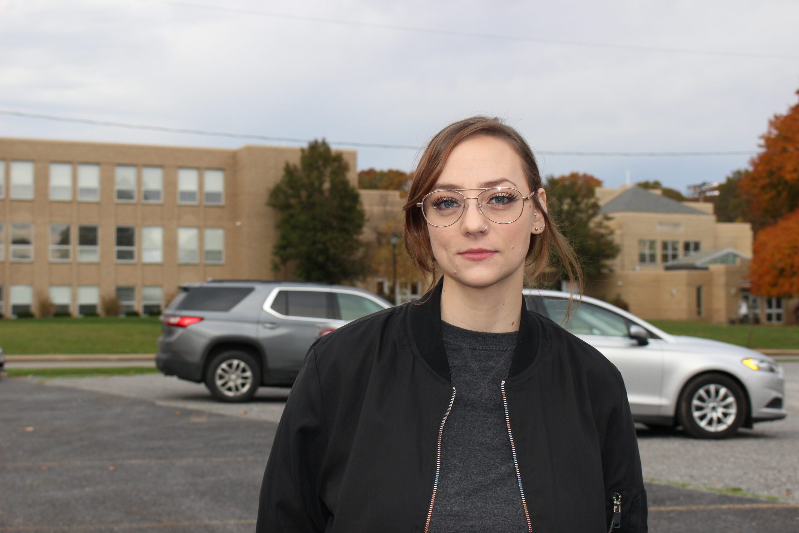 Zsuzsa Gyenes stands in a parking lot.