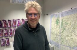 Michael Hermann with a display of maps behind him