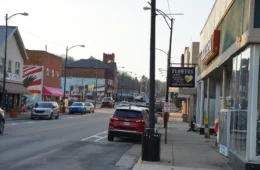 A small town business district with some cars but not people.