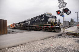 A Norfolk Southern locomotive crossing over a street