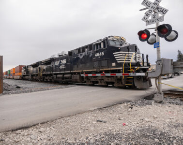A Norfolk Southern locomotive crossing over a street