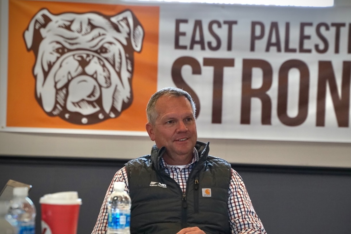 Alan Shaw sits in front of a banner that reads "East Palestine Strong."