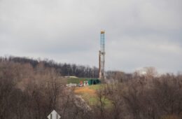A drilling rig on a hill with trees below