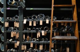 Rolls of maps with hand written tags hanging over shelves.