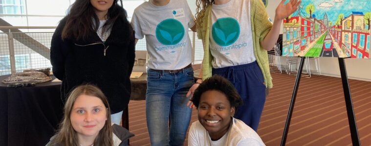 Five smiling young people in climate change tee shirts pose together