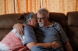 A man and a woman on a couch, embracing.