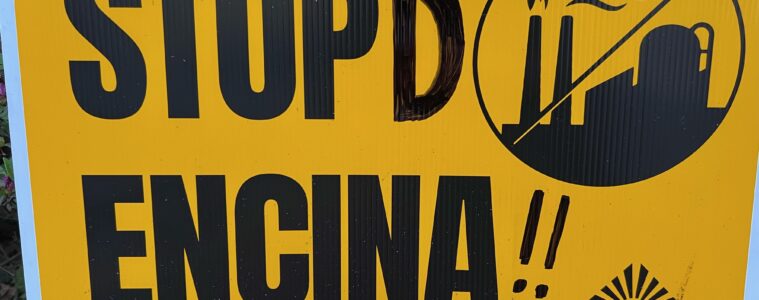 A tellow sign with bold, black lettering against the Encina plant in Point Township.