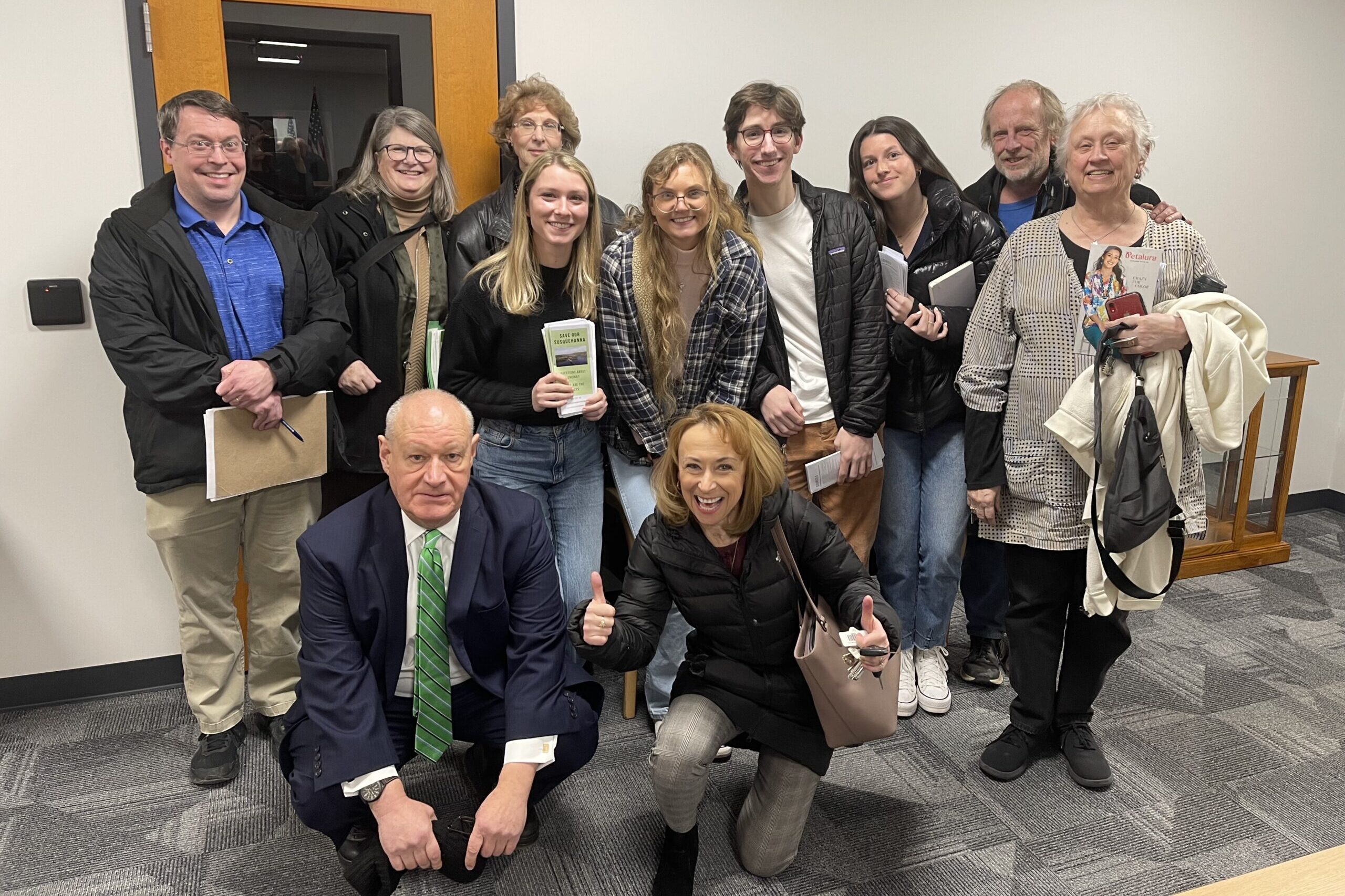 Eleven people pose together at a zoning board hearing.