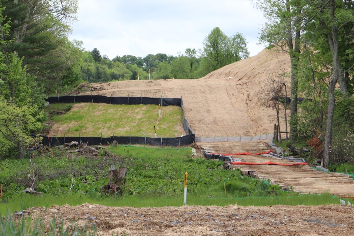 A section of pipeline under brown dirt clearing amid green trees near Bent Mountain, Virginia.