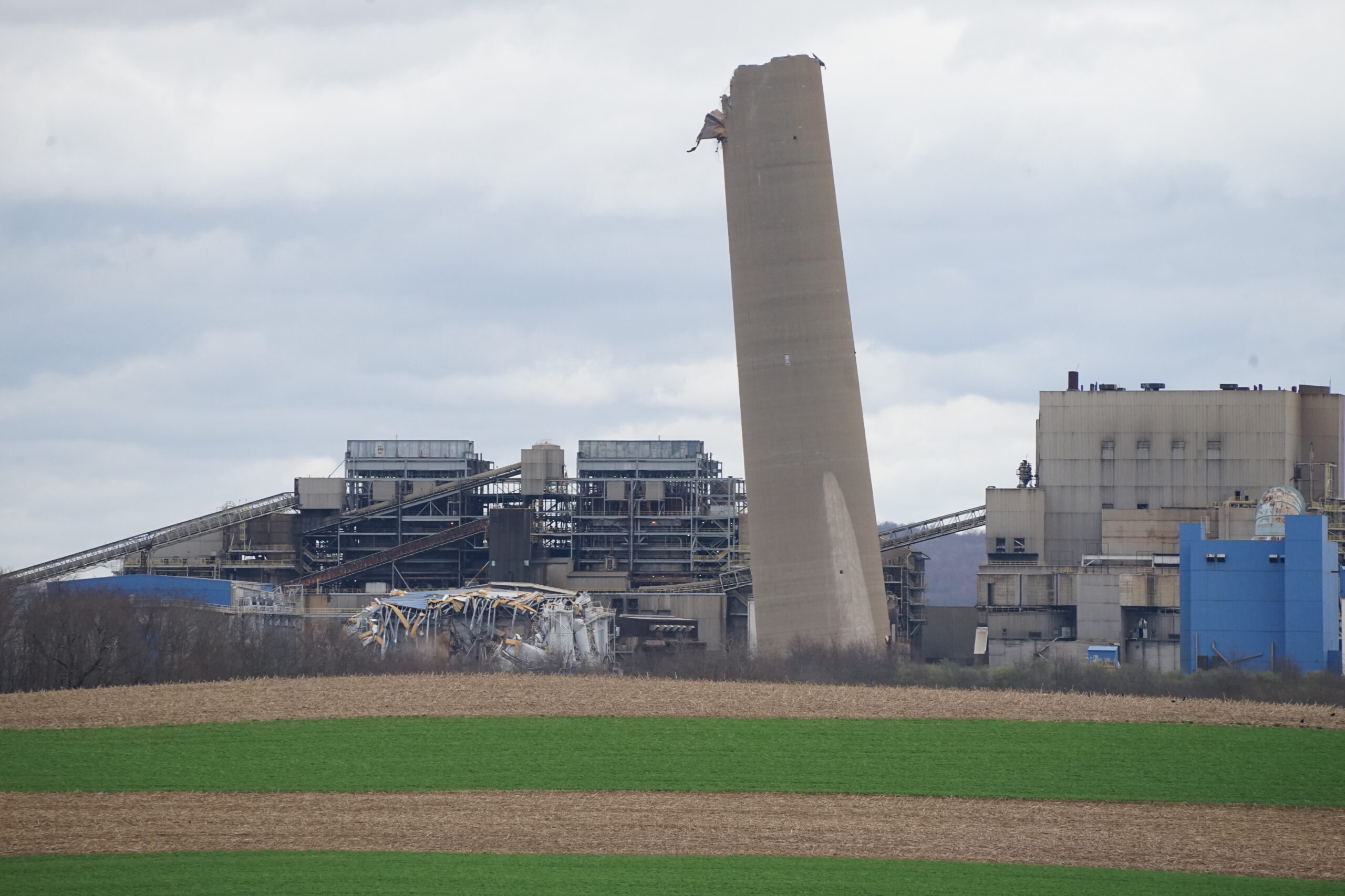 A remaining smoke stack amid rubble.