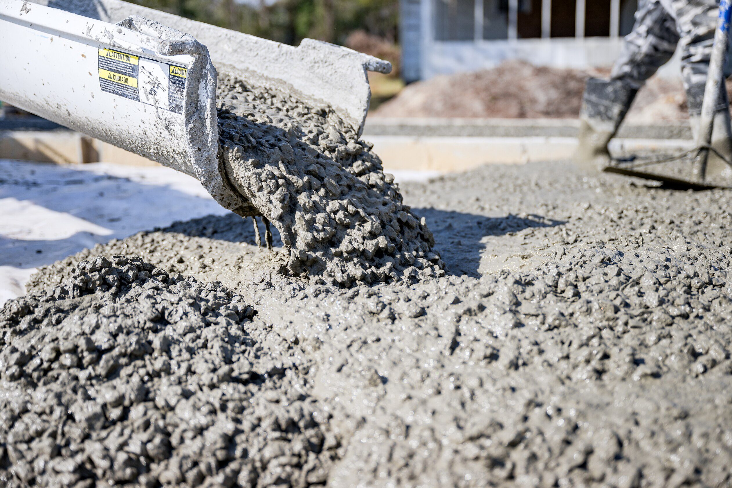 Gray, wet concrete pouring out of a slide