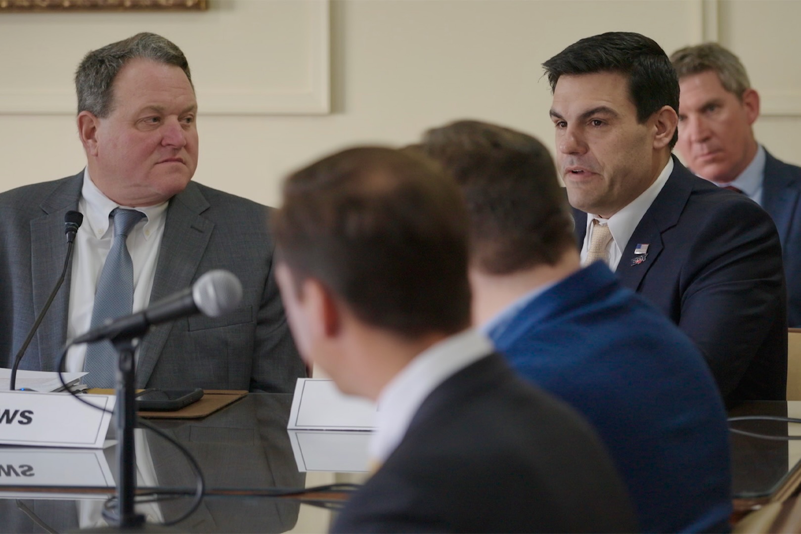 Toby Rice sits at a table with other men.