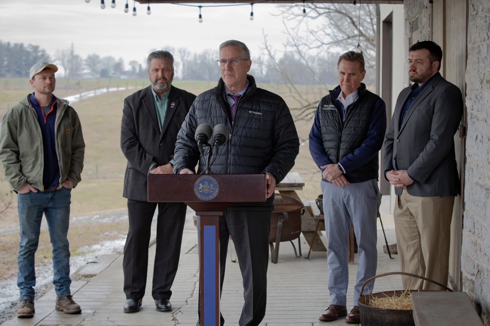 Men stand around a podium.